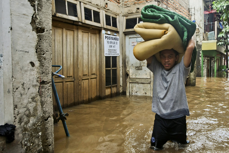 A man tries to save his property, as water entered his home in Rawajati, South Jakarta, on Monday (05/02). (JG Photo/Yudha Baskoro)