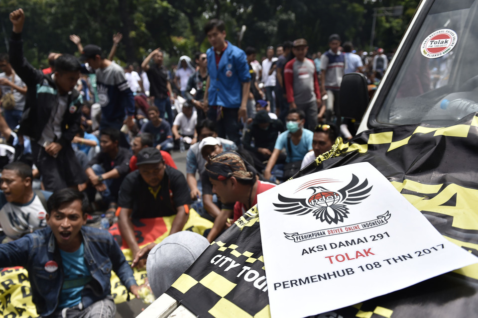 hundreds of ride-hailing service drivers who were protesting against the new regulation in front of the presidential palace in Jakarta. (Antara Photo/Puspa Perwitasari)