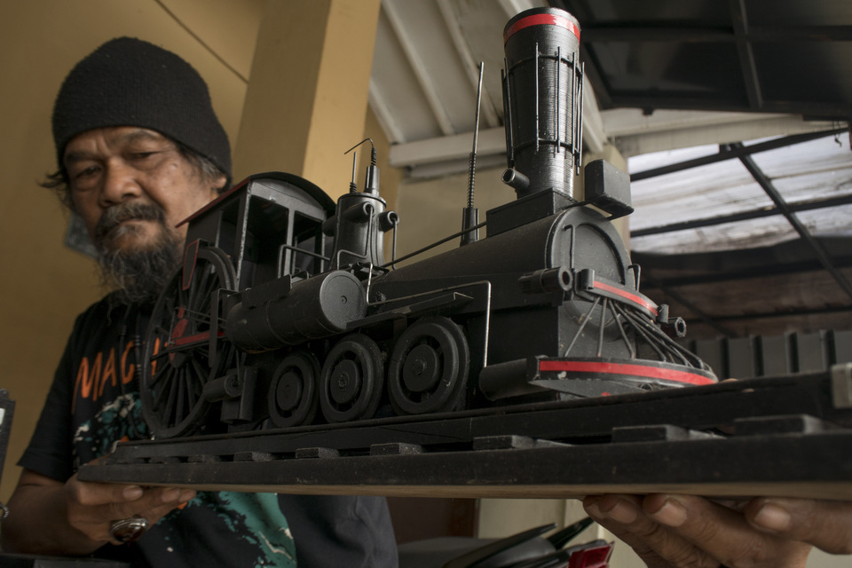 A man shows off a toy locomotive made from recycled waste in Bandung, West Java, on Feb. 2. Miniatures of various sizes are made from garbage and waste collected from the Cikapundung River. (Antara Photo/Novrian Arbi)