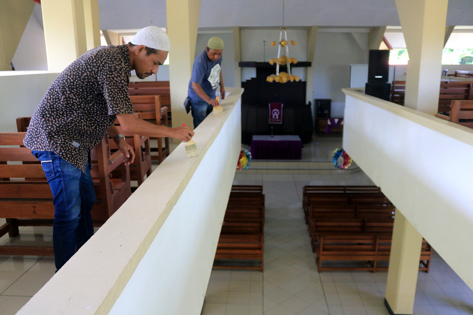 Muslim men in Ambon, Maluku, help paint a church on Thursday (22/02). (Antara Photo/Izaac Mulyawan)