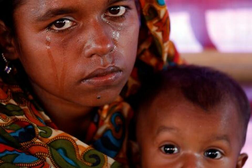 Aisha Begum, a-19 year-old Rohingya refugee, holds her daughter and cries as she tells her story at the camp for widows and orphans inside Balukhali Camp near Cox's Bazar in Bangladesh on Dec. 5, 2017. (Reuters Photo/Damir Sagolj)