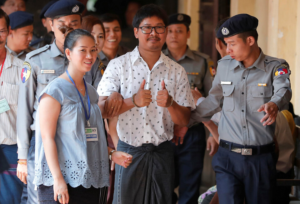 Detained Reuters journalist Wa Lone, center, is escorted by police and his wife as he arrives for a court hearing in Yangon, Wednesday (21/03). (Reuters Photo)