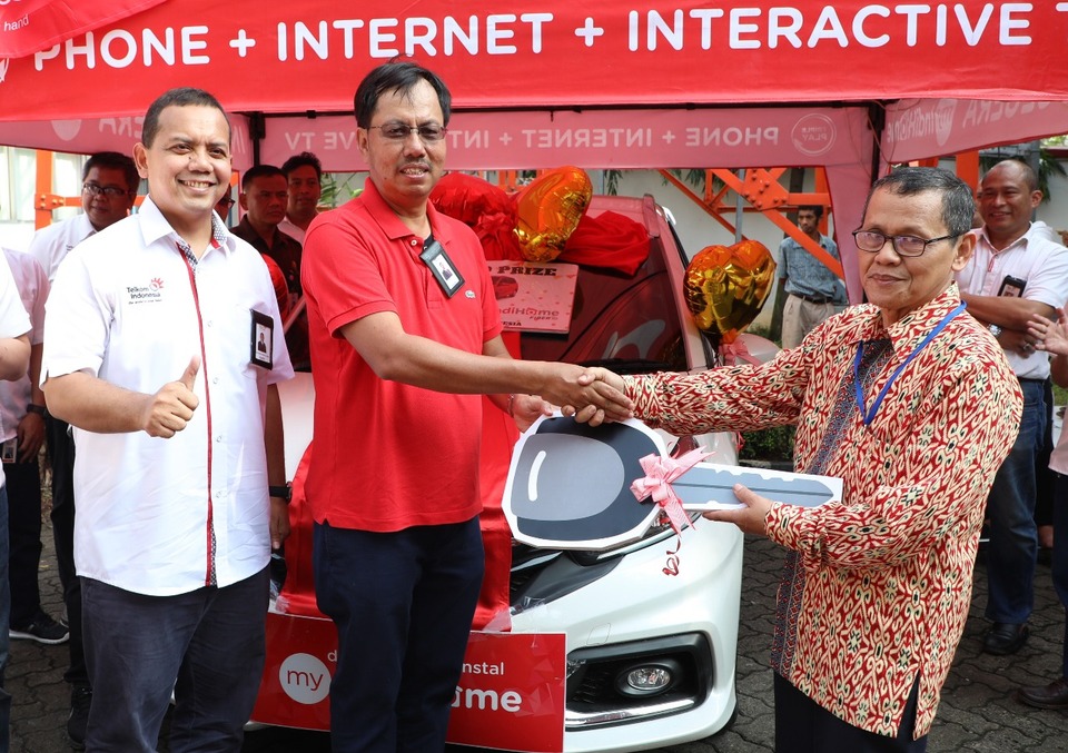 Telkom Indonesia consumer service director Mas'ud Khamid, center, is accompanied by Telkom executive vice president Teuku Muda Nanta, left, while handing over the Indihome Specta Grand Prize to the winner in Jakarta on Monday (19/03). (Photo courtesy of Telkom Indonesia)