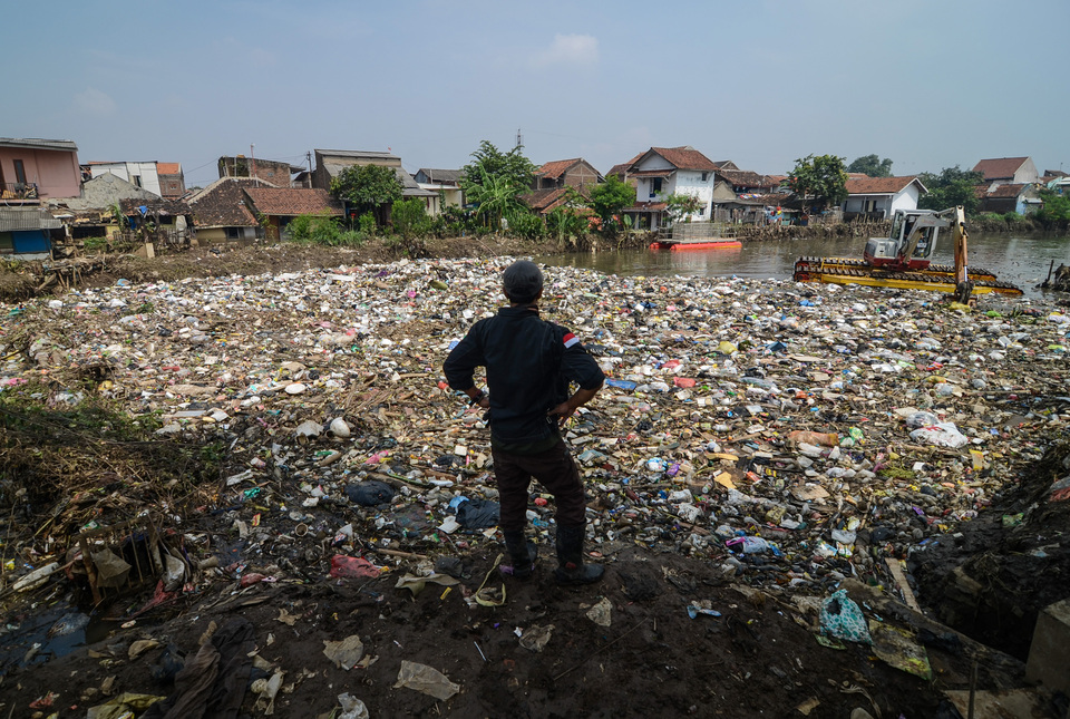 A man is looking at the garbage left after the Cikapundung River floodwaters receded in Cijagra, Bandung, West Java, on Wednesday (07/03). The river carries some 30 tons of garbage a day, which later enters the Citarum River. (Antara Photo/Raisan Al Farisi)