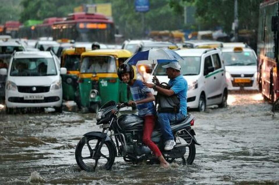 A man rides his motorcycle through a flooded road during monsoon rains in New Delhi. (Reuters Photo/Cathal McNaughton)