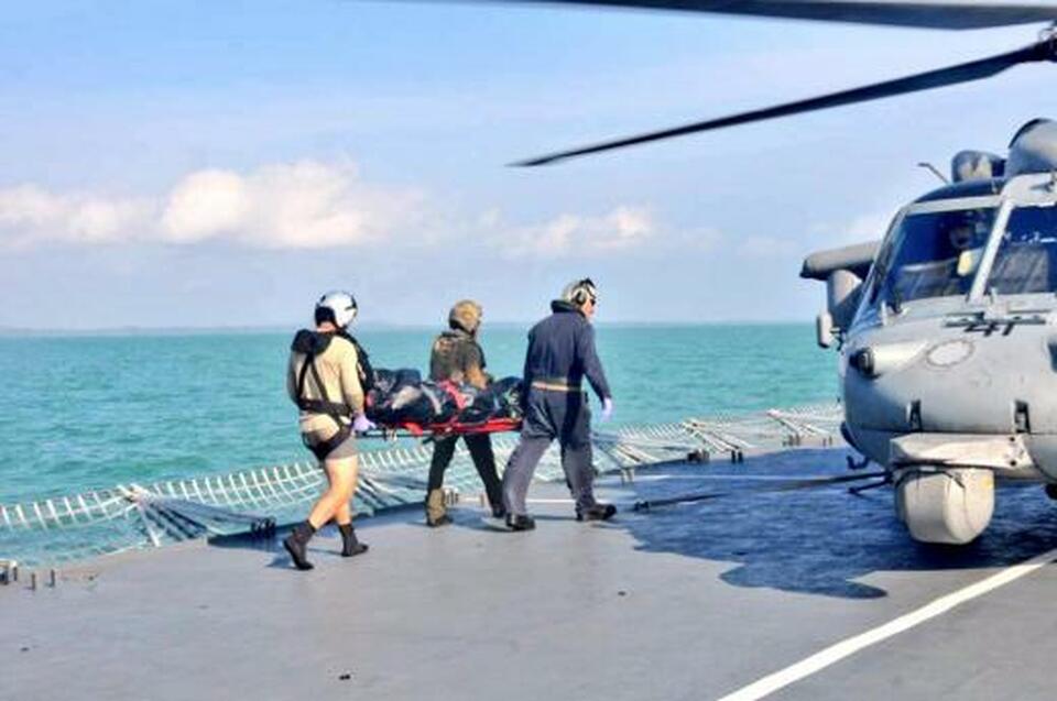 Royal Malaysian Navy personnel carry a body onto a US Navy helicopter from USS America during a search and rescue operation for survivors of the USS John S. McCain ship collision in Malaysian waters Aug. 23. (Reuters Photo/Royal Malaysian Navy)