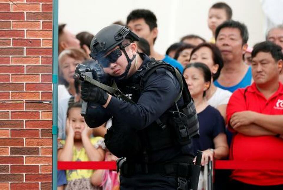 Police take part in a simulated gunmen attack demonstration for the public at a housing estate in Singapore on Dec. 10, 2017. (Reuters Photo/Edgar Su)