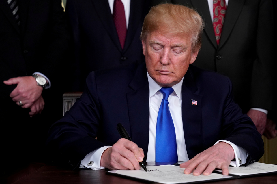 US President Donald Trump signs a memorandum on intellectual property tariffs on high-tech goods from China, at the White House on March 22. (Reuters Photo/Jonathan Ernst)