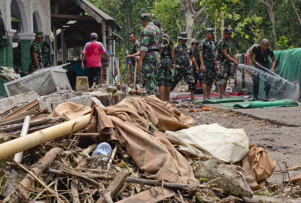 TNI soldiers are cleaning materials carried by flood in East Lombok, West Nusa Tenggara on Tuesday (21/11). (Antara Photo/Ahmad Subaidi)