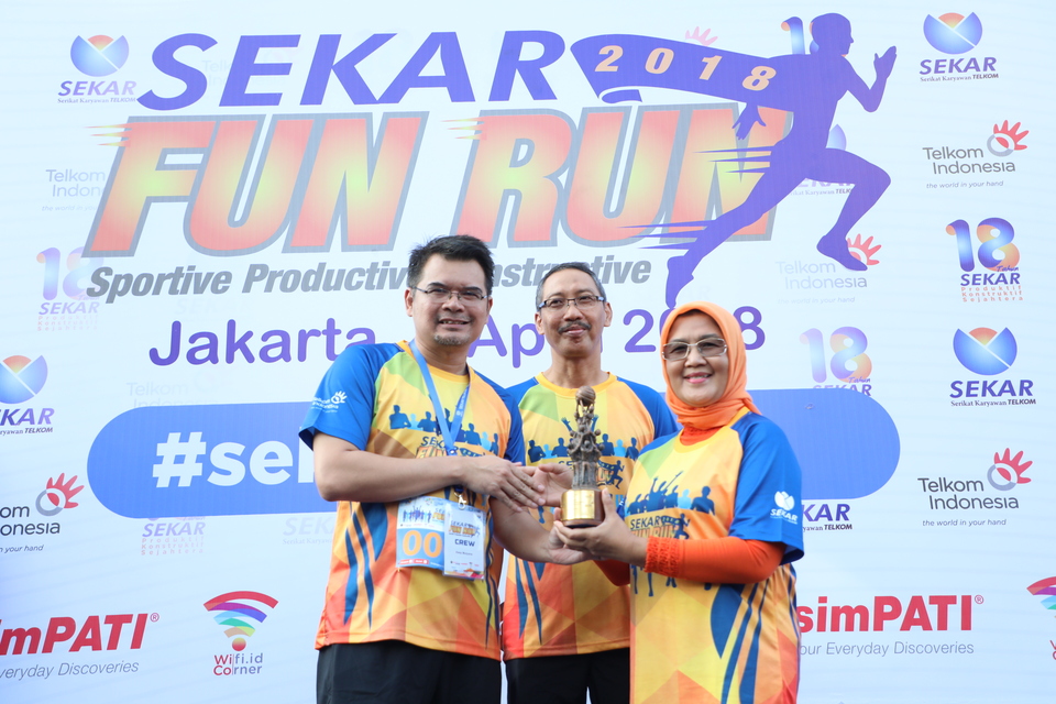 Director General of Industrial Relations Development and Social Security Manpower Ministry of Labor Haiyani Rumondang (right) received a placard submitted by Chairman of SEKAR Telkom Asep Mulyana (left) witnessed by Wholesale and International Services Director Telkom Abdus Somad Arief (center) during the opening of SEKAR Telkom Fun Run 2018 in Jakarta, Sunday (8/4).