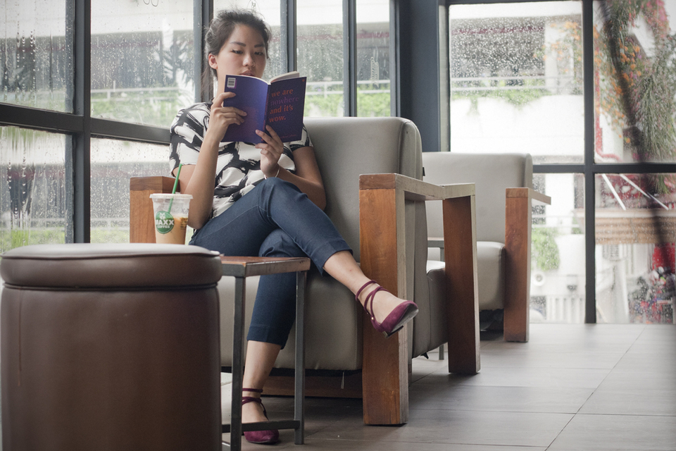 A woman reads 'We Are Nowhere And It's Wow,' a poetry collection by Indonesian poet Mikael Johani. Written in English, it touches on the experiences of being a third-culture kid. (JG Photo/Yudha Baskoro)
