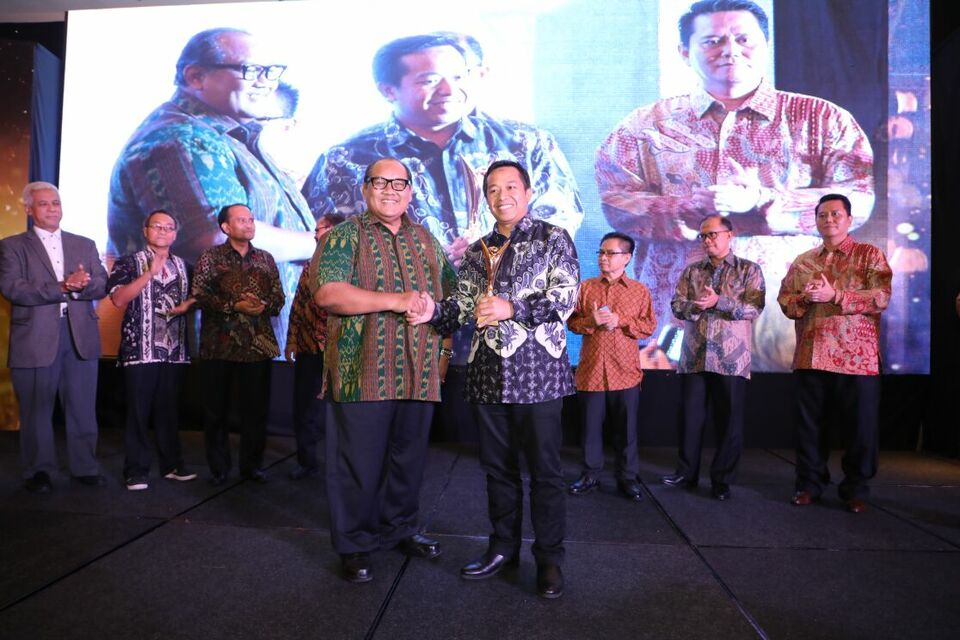 Telkom Indonesia's Dharma Syahputra, right, accepts the best state-owned enterprise award on behalf of the company from former State-Owned Enterprises Minister Soegiharto during the 2018 SOE Mental Revolution Awards in Jakarta on April 25. (Photo courtesy of Telkom)