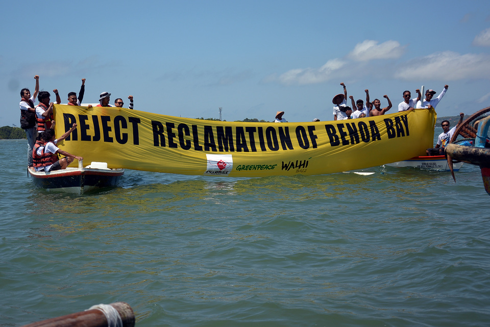 Protesters with the Balinese People's Forum Reject Reclamation group and Greenpeace activists demonstrate in an effort to stop the reclamation project of Benoa Bay in Bali on Saturday (14/04). The protesters encircled the waters of Benoa Bay and revealed banners to demand that the government annul a presidential regulation that is the basis of land reclamation in the area. (Antara Photo/Wira Suryantala)

