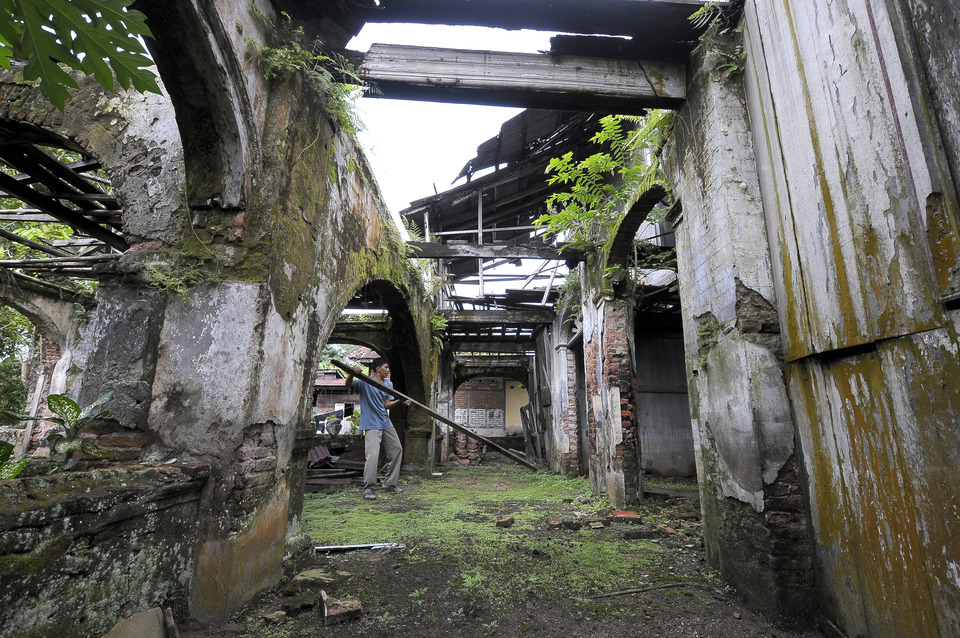 A man picks up debris at a 19th-century house in Olak Kemang, Teluk Lake, Jambi, Tuesday (24/04). The historical building, which remembers the Sultanate of Jambi, has been left to rot with no restoration attempts from the local government. (Antara Photo/Wahdi Septiawan)