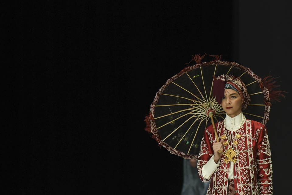 The model wears an outfit by designer Itang Yunas during the show 'Heritage of Ancient Komodo' at Indonesia Fashion Week 2018 in Senayan, South Jakarta, on Friday (30/03). (Antara Photo/Hafidz Mubarak A)