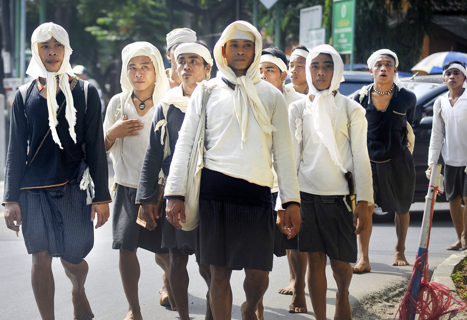 Members of the Baduy Dalam tribe walking from Ciboleger in Lebak district, Banten, to the offices of the provincial governor in Serang to attend the Seba Baduy ceremony on Saturday (21/04). The ceremony, which takes place after the harvest season every year, serves to maintain a channel of communication between the traditional community and the government. The Baduy consists of two sub-groups – Baduy Dalam (Inner Baduy) and Baduy Luar (Outer Baduy). They resist foreign influences and vigorously preserve their ancient way of life, such as shunning modern forms of transportation. (Antara Photo/Asep Fathulrahman)