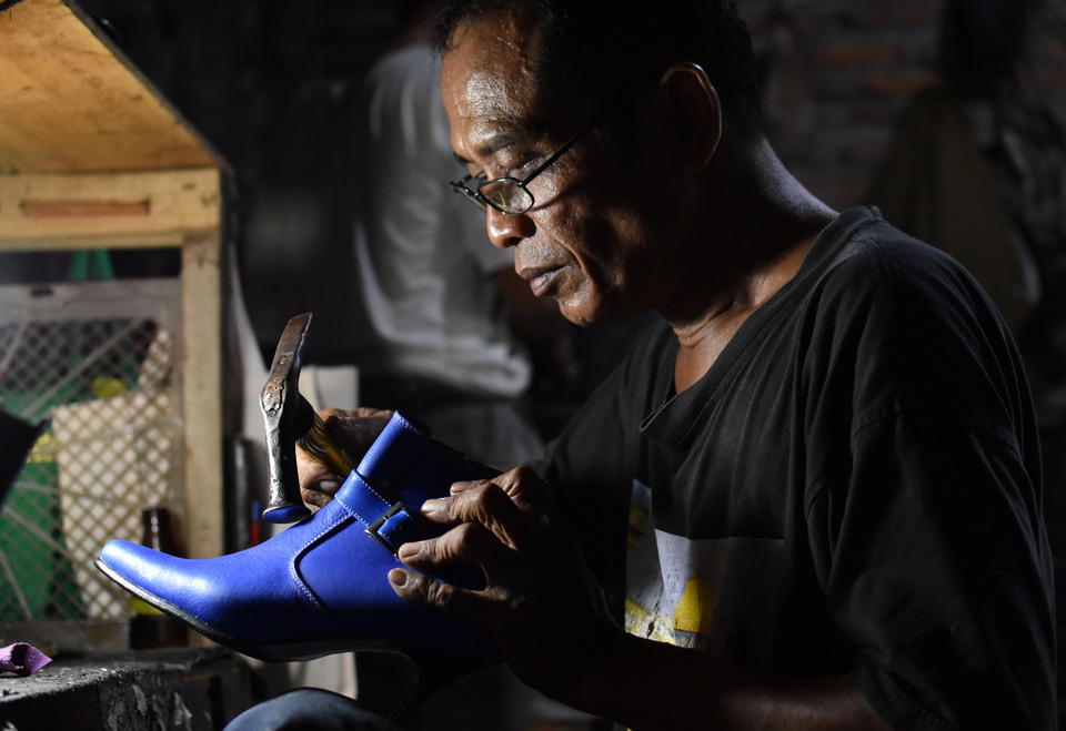 A cobbler makes leather shoes in Rejomulyo, Semarang, Central Java, on Friday (27/04). Indonesian footwear exports have been growing at a 2 percent rate annually. (Antara Photo/Aditya Pradana Putra)