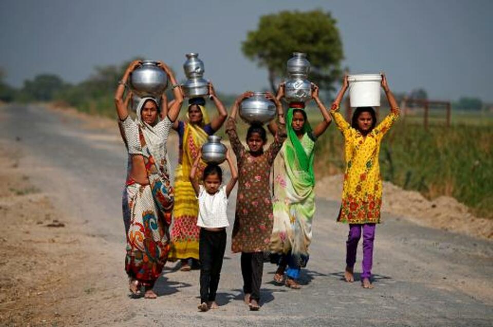 Village women and girls carry water at Fangadi Village on the outskirts of Ahmedabad, India. (Reuters Photo/Amit Dave)