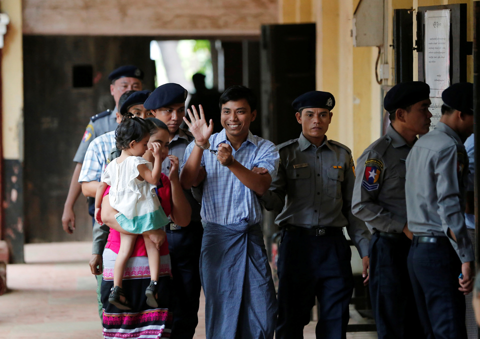 Detained Reuters journalist Kyaw Soe Oo, center, escorted by police and his wife arrives for a court hearing in Yangon, Myanmar, on April 25, 2018. (Reuters Photo)