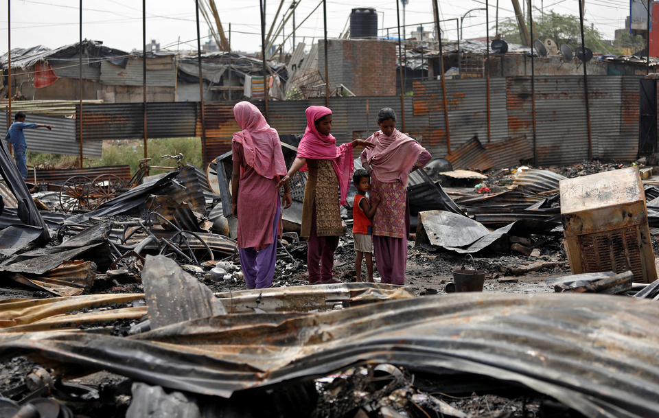Rohingya women stand on the debris of their houses after a fire broke out in their camp in New Delhi, India, May 15. (Reuters Photo/Saumya Khandelwal)