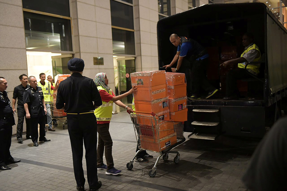 A Malaysian police officer pushes a trolley during a raid of three apartments in a condominium owned by former Malaysian prime minister Najib Razak’s family, in Kuala Lumpur, May 17. (Reuters Photo/The Straits Times)