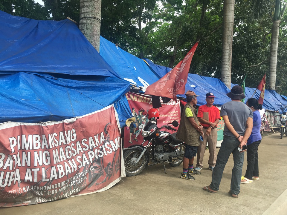 Activists and farmers demanding land stand at their camp outside the provincial agriculture office in Tagum City, Philippines. (Reuters Photo/Rina Chandran)