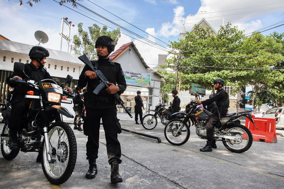 Members of the Riau Police Mobile Brigade guard a church in the provincial capital Pekanbaru following the Surabaya church bombings on Sunday (13/05). (Antara Photo/Rony Muharrman)