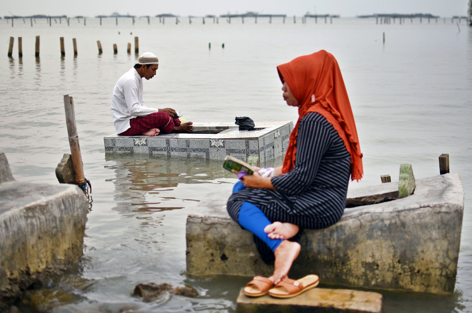 Worshipers make the pilgrimage to the now-submerged graves of loved ones in Tambaklorok, Semarang, Central Java, on Wednesday (16/05) to mark the start of Ramadan. (Antara Photo/Aditya Pradana Putra)