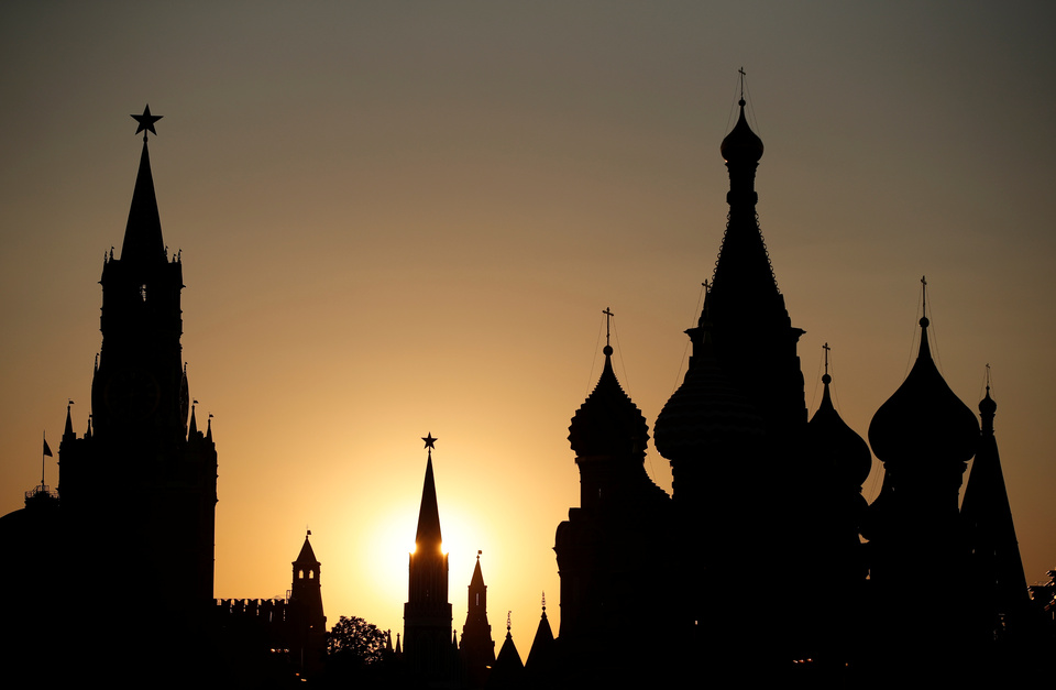 The sun sets behind the Kremlin's Spasskaya Tower and St. Basil's Cathedral in Moscow, Russia, June 18, 2018.  (Reuters Photo/Christian Hartmann)