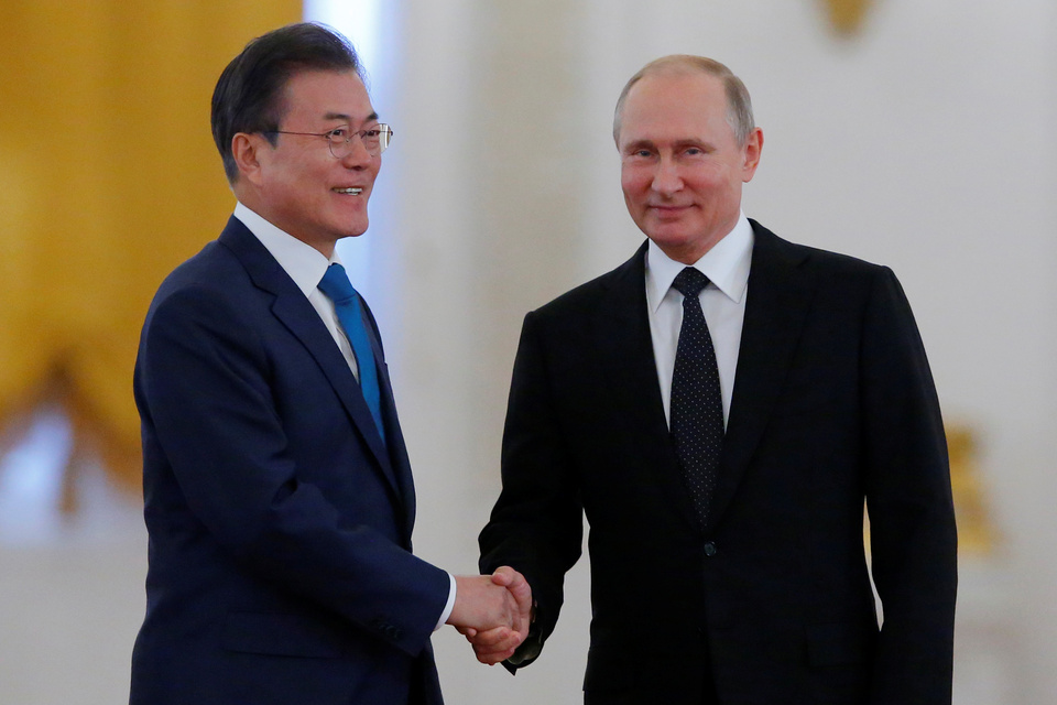 Russian President Vladimir Putin and South Korean President Moon Jae-in attend a welcoming ceremony at the Kremlin in Moscow, Friday (22/06). (Reuters Photo/Sergei Karpukhin)