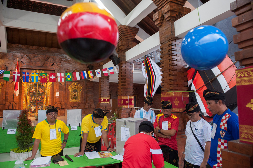 Election officials prepare for the start of voting for local elections at a polling station with a World Cup theme in Badung, Bali, Indonesia June 27, 2018  ( Antara Foto/Nyoman Budhiana)