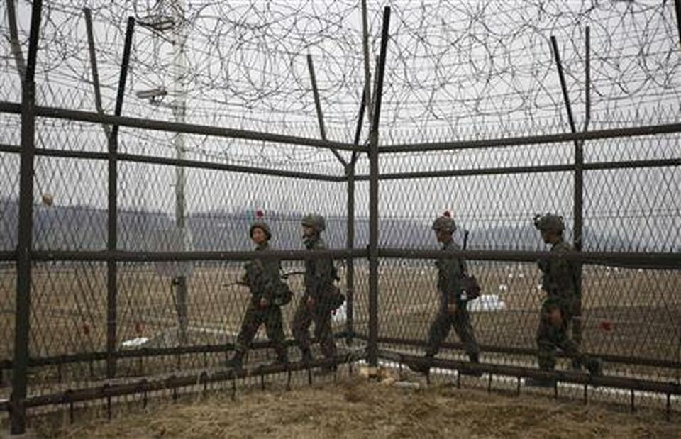 South Korean soldiers patrol along a barbed-wire fence, near the demilitarized zone (DMZ) which separates the two Koreas in Paju, north of Seoul. (Reuters Photo/Kim Hong-Ji)