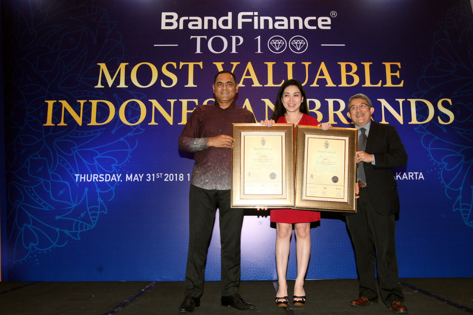 Liryawati, middle, accepts a Top 100 Most Valuable Brands 2018 award from the managing director of Brand Finance Asia Pacific, Samir Dixit, left, and general manager of SWA Magazine, E. Gani, on Thursday (31/05). (Photo courtesy of BOLT)