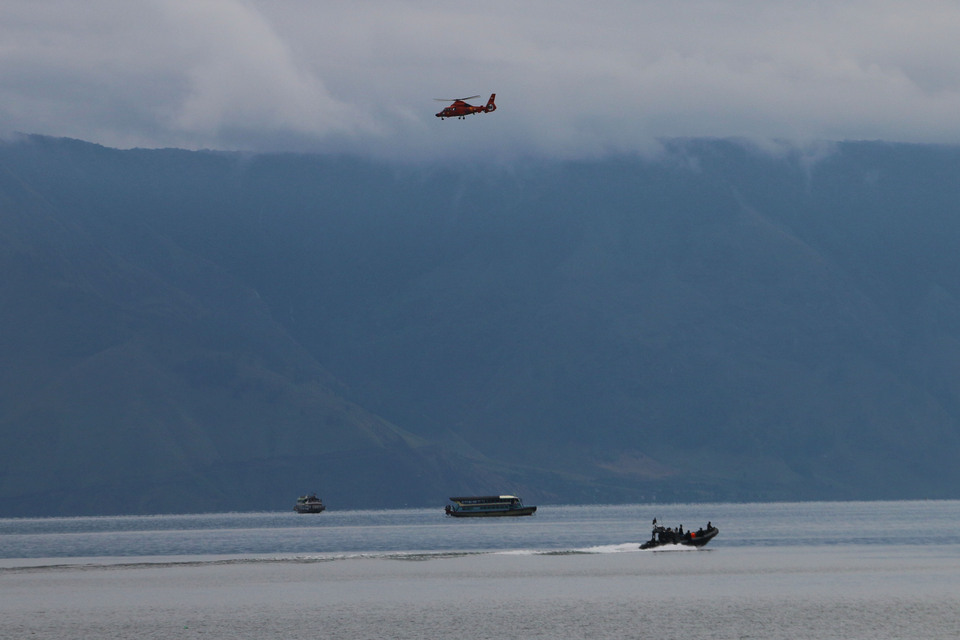 A helicopter flies over Lake Toba in search of the victims of the KM Sinar Bangun ferry accident in Simalungun, North Sumatra, on Saturday (23/06). Many are still missing. (Antara Photo/Irsan Mulyadi)