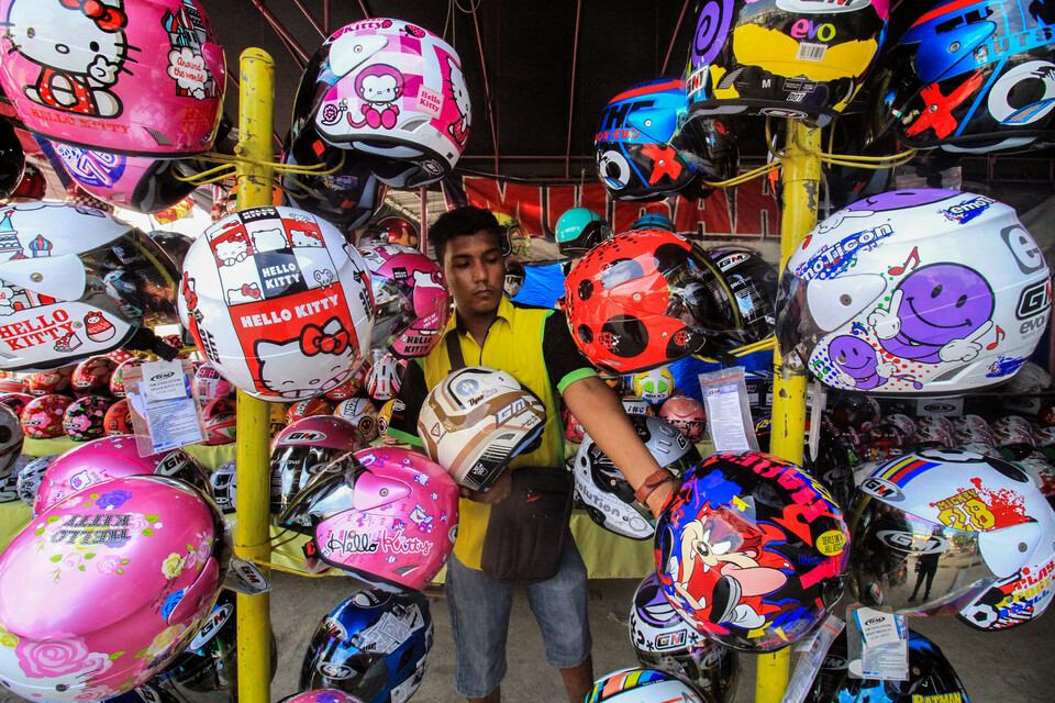 A man sells helmets at Merdeka Timur in Lhokseumawe, Aceh, on Thursday (07/06). According to traders, demand for Indonesian National Standard-certified helmets ahead of the Idul Fitri homecoming made the prices rise from Rp 150,000 ($10) to Rp 1 million. (Antara Photo/Rahmad)