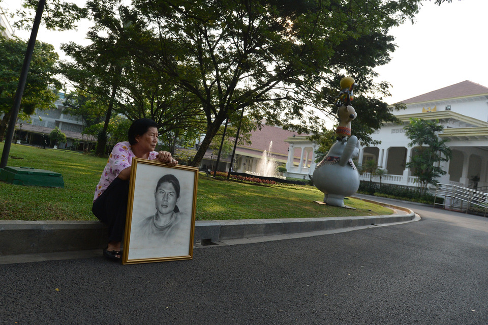 A member of the Kamisan protest movement holds a sketch of her child following a meeting between President Joko 'Jokowi' Widodo and survivors and relatives of victims of past human rights abuses at the State Palace in Central Jakarta on Thursday (31/05). Kamisan is a silent protest that has been held in front of the State Palace every Thursday since 2007 to demand that the government resolve cases of past human rights violations. (Antara Photo/Wahyu Putro A)