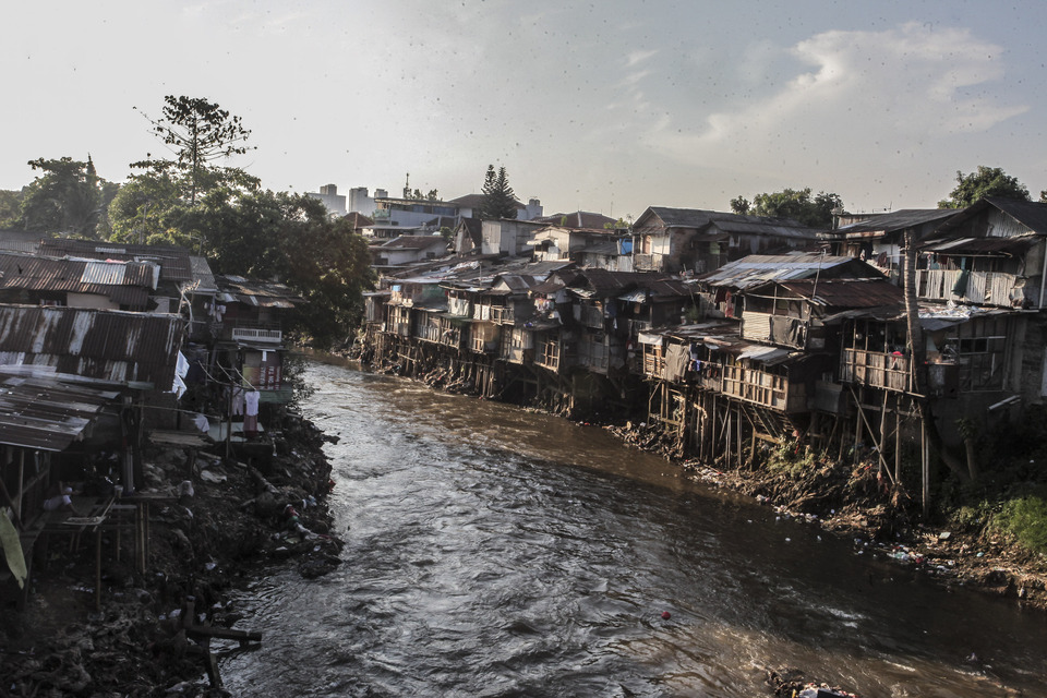Shanties are spread along the Ciliwung River, Jakarta, on Sunday (17/06). Jakarta Governor Anies Baswedan is soon going to enact a new regulation on slum areas. (Antara Photo/Muhammad Adimaja)