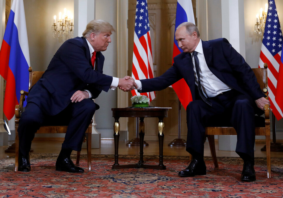 US President Donald Trump and Russia's President Vladimir Putin shake hands as they meet in Helsinki, Finland, Monday (16/07). (Reuters Photo/Kevin Lamarque)