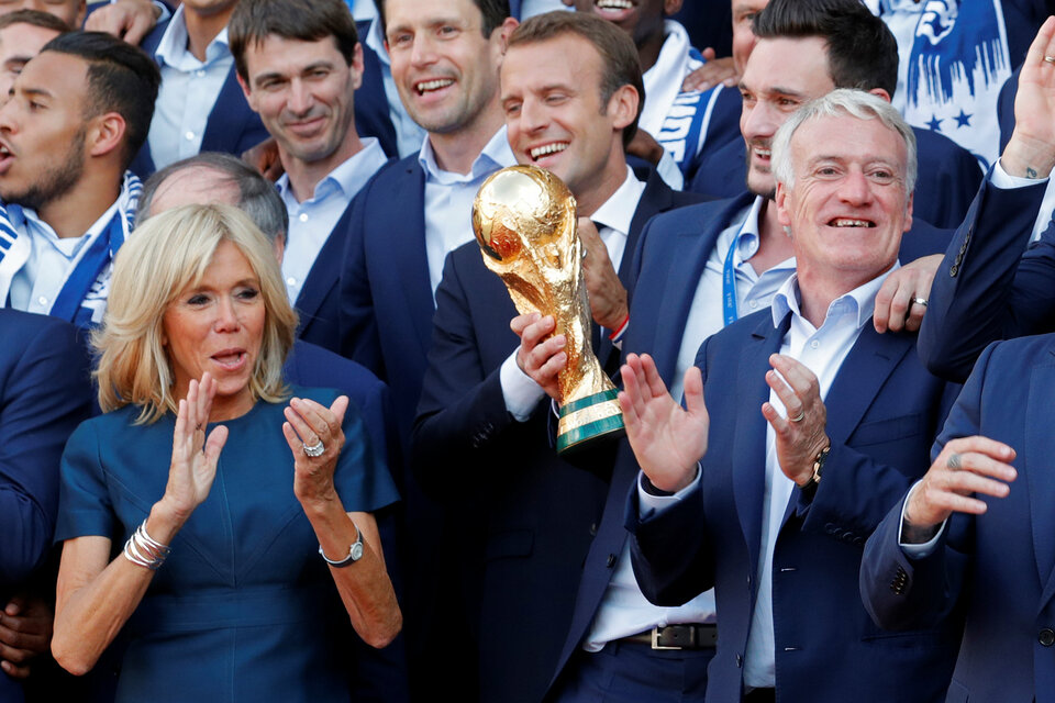 French President Emmanuel Macron and his wife Brigitte Macron pose with France football team captain Hugo Lloris and coach Didier Deschamps and players before a reception to honor the France football team after their victory in the 2018 Russia Football World Cup, at the Elysee Palace in Paris, France, Monday (16/07). (Reuters Photo/Philippe Wojazer)