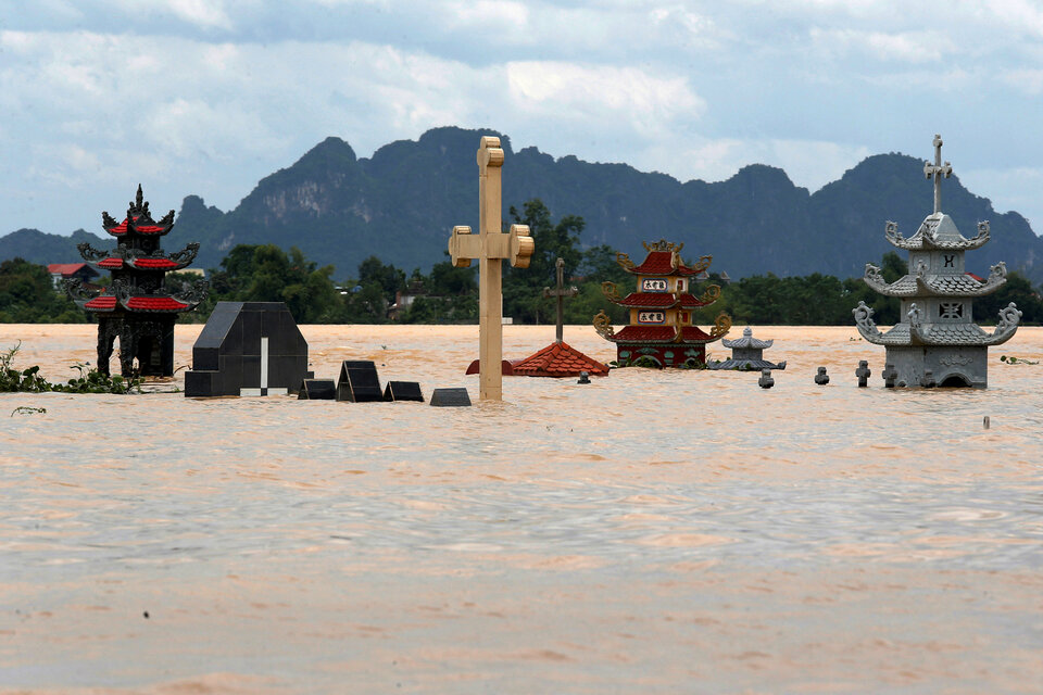 Submerged tombs are seen at a flooded village after heavy rainfall caused by tropical storm Son Tinh in Ninh Binh province, Vietnam, Sunday (22/07). (Reuters Photo/Kham)