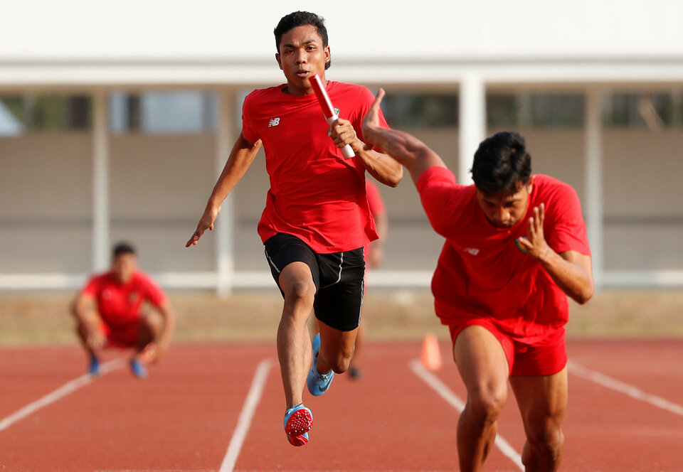 Indonesian sprinter Lalu Mohammad Zohri holds a baton as he runs during a relay practice ahead of the Asian Games in Jakarta, Friday (27/07). (Reuters/Beawiharta) 