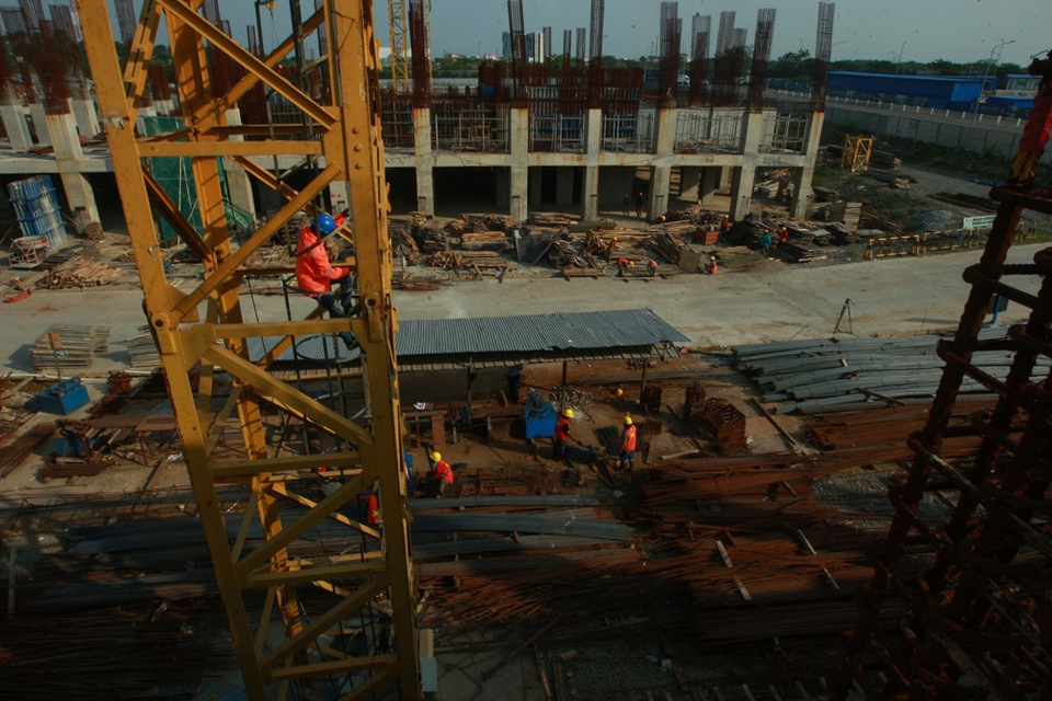 Workers descend from a crane at the international municipal development project Meikarta. (JG Photo/Yudhi Sukma Wijaya)