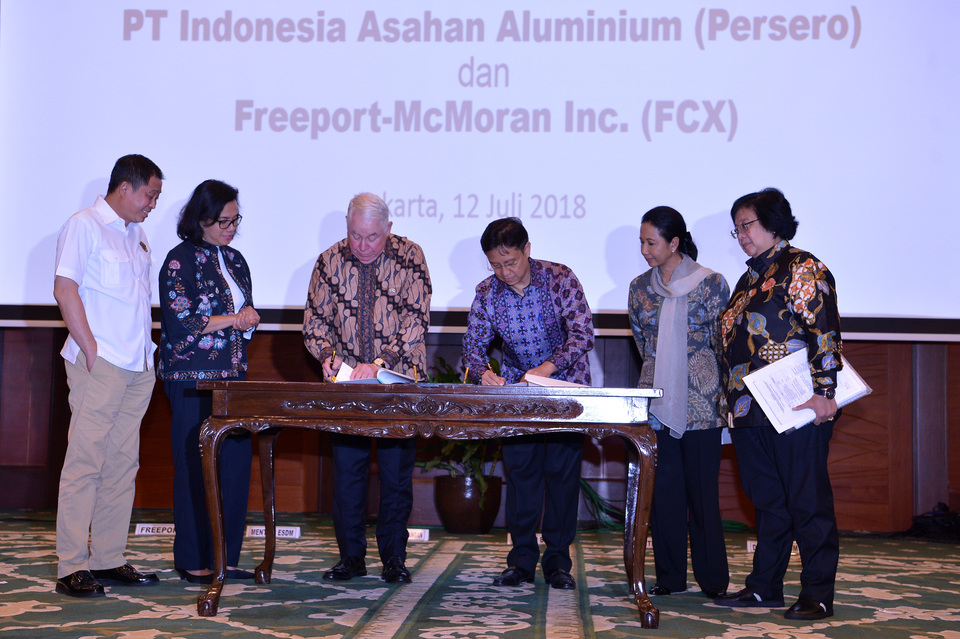 Energy and Mineral Resources Minister Ignatius Jonan, left, Finance Minister Sri Mulyani, Environment Minister Siti Nurbaya, right, and SOE Minister Rini Soemarno witness the signing of the head of agreement between Inalum president director Budi Gunadi, third right, and Freeport McMoran president director Richard Adkerson, second left, on Freeport Indonesia divestment, in Jakarta on Thursday (12/07). (Antara Photo/Wahyu Putro A)