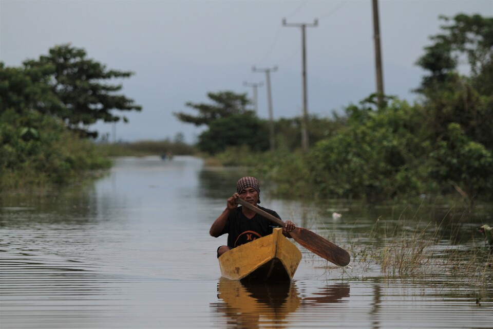 A man rows a boat to his home after flood waters cut off access to Laloika village in Konawe, Southeast Sulawesi, Friday (06/07). Five villages in the district have been isolated by the overflowing Konaweha and Lahambuti River. (Antara Photo/Jojon)