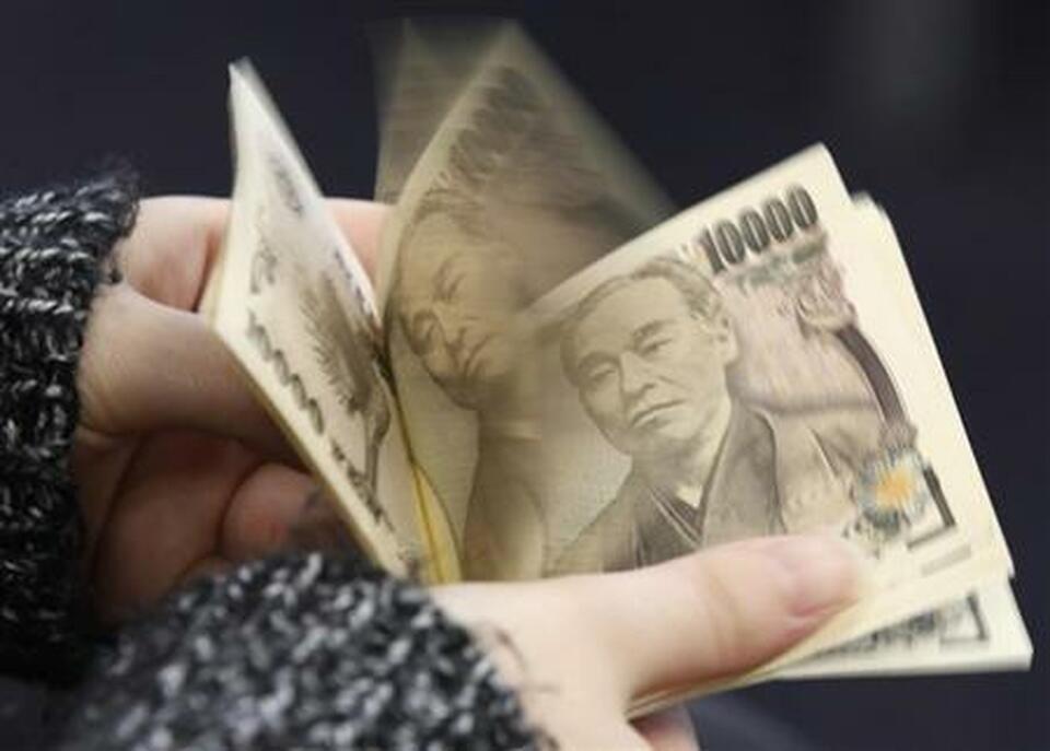 A woman counts Japanese 10,000 yen notes in Tokyo. (Reuters Photo/Shohei Miyano)