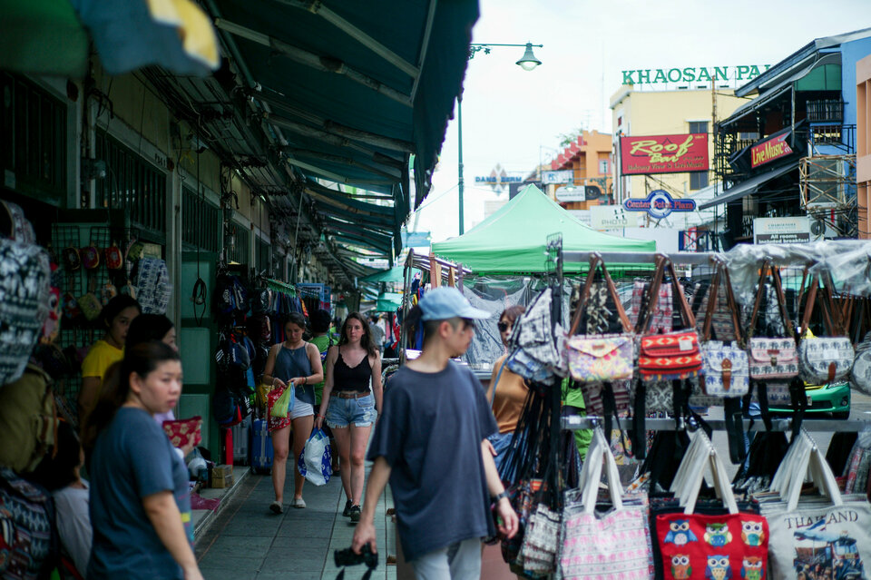 Tourists walk past street vendor shops at the Khao San tourist street in Bangkok, Thailand, Wednesday (01/08). (Reuters Photo/Panu Wongcha-um)