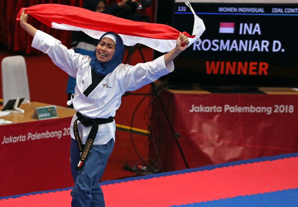 Defia Rosmaniar of Indonesia celebrates her victory in women's individual poomsae on Sunday (19/08). (Reuters Photo/Cathal Mcnaughton)