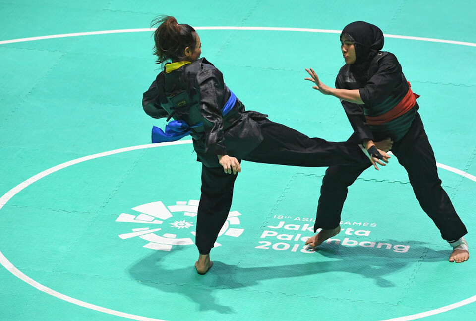 Pipiet Kamelia of Indonesia, right, seen in action against Nguyen Thi Cam Nhi  of Vietnam in the final round of the 2018 Asian Games pencak silat women's Class D event at Taman Mini Indonesia Indah in East Jakarta on Wednesday (29/08). (Antara Photo/Inasgoc/Melvinas Priananda)