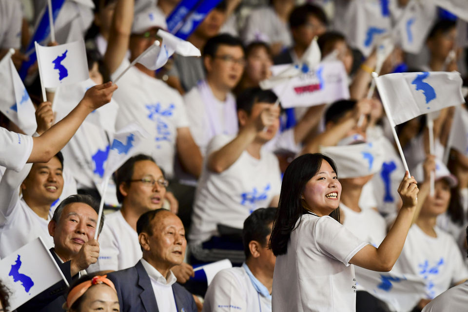 Unified Korea supporters cheer for their team during a game against India on Monday (20/08). (JG Photo/Yudha Baskoro)