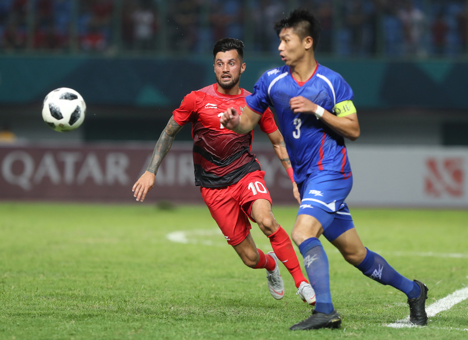 Indonesia's Stefano Lilipaly, right, and Taiwan's Tingyang Chen compete for the ball in their Asian Games  Group A match at Patriot Chandrabaga Stadium in Bekasi, West Java, on Sunday (12/08). (Photo courtesy of Inasgoc)
